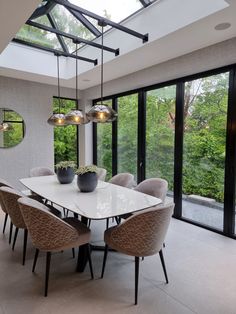 a dining room table surrounded by chairs and lights