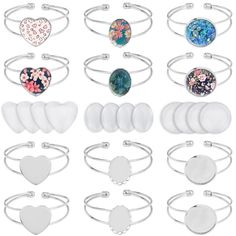 a bunch of different types of bracelets and rings on a white background with flowers