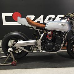 a silver motorcycle parked in front of a sign with the word garage on it's side