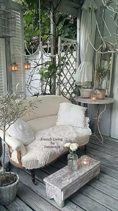 a white couch sitting on top of a wooden floor next to a table and potted plant