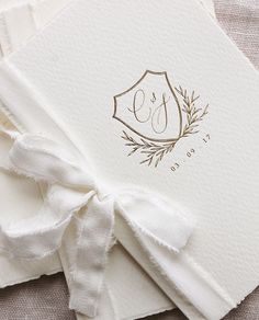 wedding guest book with monogrammed initials and ribbon tied around the front, folded in white paper