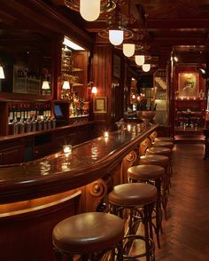 a dimly lit bar with stools and lights