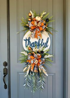 a front door wreath with the words thank you and an orange bow hanging on it