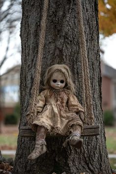 a creepy doll is sitting on a swing