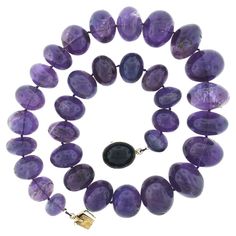 This magnificent vintage strand necklace was neatly strung with 32 natural genuine amethyst in which graduate from 15.6mm to 26mm in diameter throughout. Each of these rondelle shaped stones have a nice polished finish and display an absolutely gorgeous medium purple color, bringing a bold and absolutely incredible look around the neck. This heavy and substantial piece closes with a large, sturdy, push clasp that is crafted from solid 14k yellow gold and is neatly bezel set with a large oval cab Multi Strand Pearl Necklace, Three Strand Necklace, Jade Bead Necklace, Miriam Haskell Jewelry, Artisan Bracelets, Deep Purple Color, Double Strand Necklace, Miriam Haskell, Medium Purple