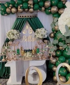 a table topped with lots of green and gold balloons