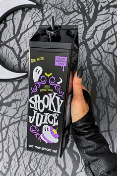 a person is holding up a halloween juice carton with the words spooky juice on it