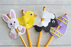 easter decorations made out of paper and pencils on a white table with wood planks