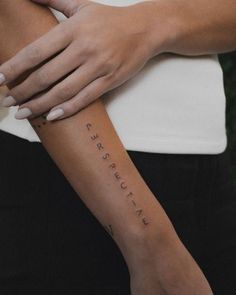 a woman's arm with the word love tattooed on her left arm, in cursive writing