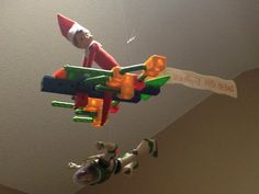 an elf is hanging from the ceiling with toys