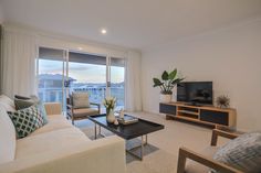 a living room filled with furniture and a flat screen tv sitting on top of a wooden stand