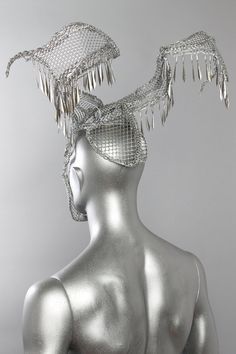 This is a one of a kind piece of wearable art made for the Five and Diamond Sixth Annual Headgear Art Show and shown on August 2, 2018. Designed and handmade by the artist: Omar António Materials: Metal mesh. Galvanized wire. Chain. Jewelry. Paint. Light weight One of a kind. Mad max beyond thunderdome. Headpiece All headgear sales are final. Due to the unique nature of these works of art, coupon codes will not be accepted. td {border: 1px solid #ccc;}br {mso-data-placement:same-cell;} Unique Handmade Ceremonial Headpieces, Handmade Silver Headpieces For Party, Best Gowns, Metal Head, Kaleidoscopes, Metal Clothing, Unique Nature, Fantasy Costumes, Carnival Costumes