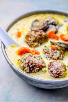 a bowl of soup with meatballs and carrots