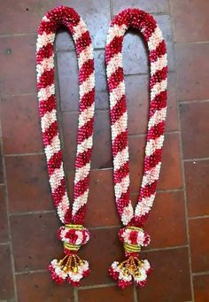 two red and white beaded necklaces on a tile floor