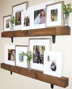 several pictures are hanging on the wall with wooden shelves holding plants and vases filled with flowers