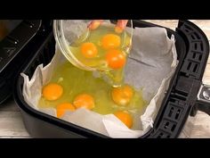 someone is pouring orange juice into an air fryer with eggs in it and on the side