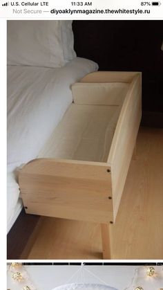 a bed with white sheets and a wooden box on the floor in front of it