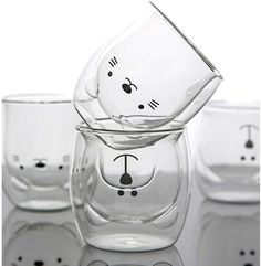 three glass cups with faces drawn on them