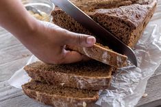 a person holding a knife over slices of bread