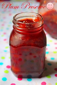 a jar filled with red liquid sitting on top of a polka dot covered table cloth