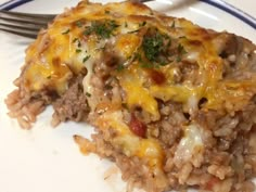 a close up of a plate of food with rice and meat on it next to a fork