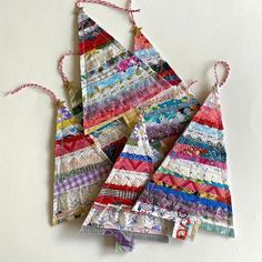 four pieces of colorful fabric hanging from strings