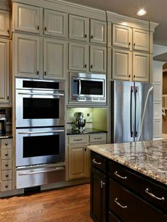 a kitchen with two ovens and an island in the middle, surrounded by cabinets