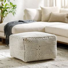 a white couch sitting next to a wooden coffee table on top of a carpeted floor