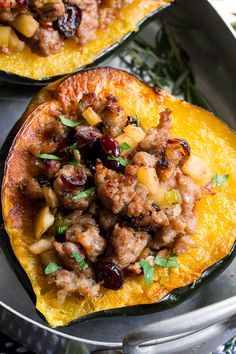 two stuffed acorns with meat and cranberries in a pan on a table