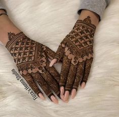 the hands are decorated with henna designs