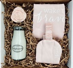 a box with some items in it and a pink rose on the top, next to a bottle of milk