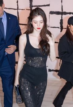 a woman in a black dress is walking