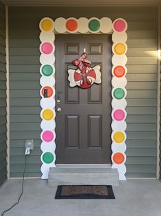 a front door decorated with colorful circles and a candy man on the top of it