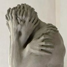 there is a white sculpture with hands on it