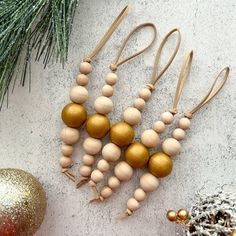 several wooden beads are hanging from a christmas ornament next to some pine cones