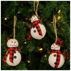 three snowman ornaments hanging from a christmas tree