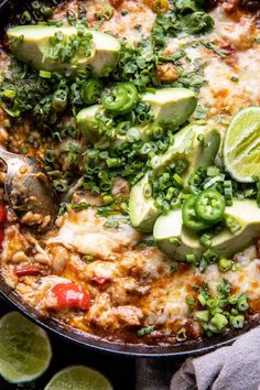 a skillet filled with mexican food and garnished with avocado slices