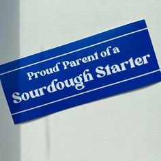 a blue sticker on the side of a refrigerator saying proud parent of a sourdough starter