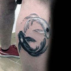 a man's leg with a black and white koi fish tattoo on it