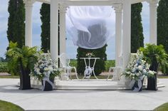 a white gazebo decorated with flowers and greenery