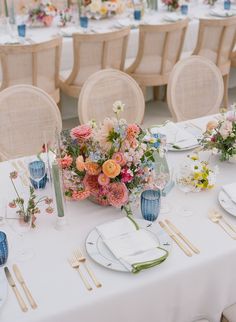 the table is set with flowers and place settings