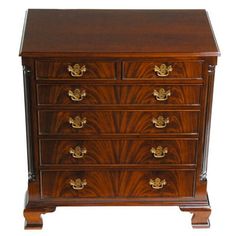 an antique chest of drawers with brass hardware and wood grained finish, on white background