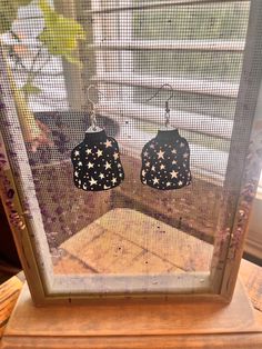 pair of black and white stars earrings sitting on top of a window sill