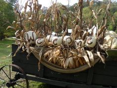 an old wagon filled with pumpkins and corn