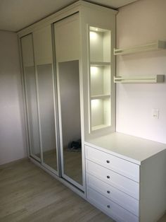 an empty room with white cabinets and drawers