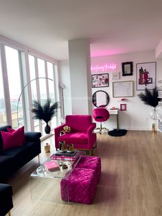 a living room filled with furniture and lots of windows next to a wall covered in pictures