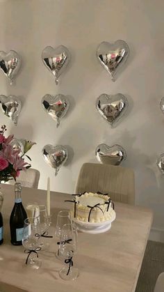 a table topped with a cake next to wine glasses and vases filled with flowers