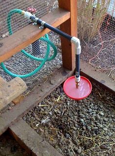 a red frisbee sitting on top of a pile of dirt next to a fence