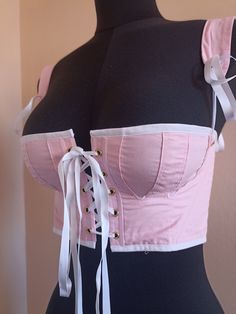 This corset is directly inspired by regency clothes and will be perfect for History bounding or historical reproduction. Daphne has a front opening as well as adjustable and removable straps for more comfort. This corset is made of pink cotton lined with white cotton. It is adorned with white satin ribbons, and stiffened with synthetic whalebone. This pair of stays will fit the measurements Waist 69cm (27in), Bust 85cm (33in). This color combination is also available for measurements Waist 61cm, Fitted Cotton Top For Costume Party, Summer Cosplay Fitted Corset, Fitted Cotton Corset For Costume, Runway Corset, Regency Short Stays, Regency Corset, Pink Corset Top, Short Stays, History Bounding