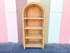 a wooden shelf sitting in front of a wall with pink and blue stripes on it